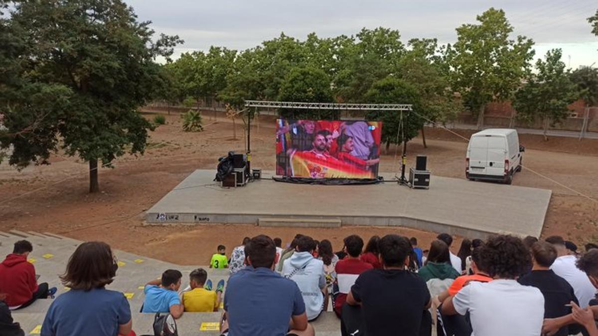 Jóvenes viendo el España-Italia en una pantalla gigante dentro del parque
