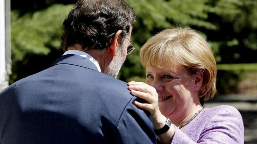 Mariano Rajoy saluda a la canciller alemana, Angela Merkel, a su llegada al Palacio de la Moncloa, ayer durante la primera visita de la mandataria germana a La Moncloa desde que el presidente español llegó al poder. / juanjo martín