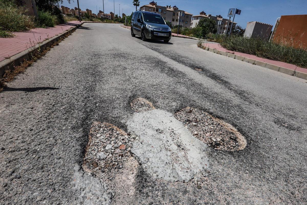Estado del asfalto de una calle en una urbanización de la costa