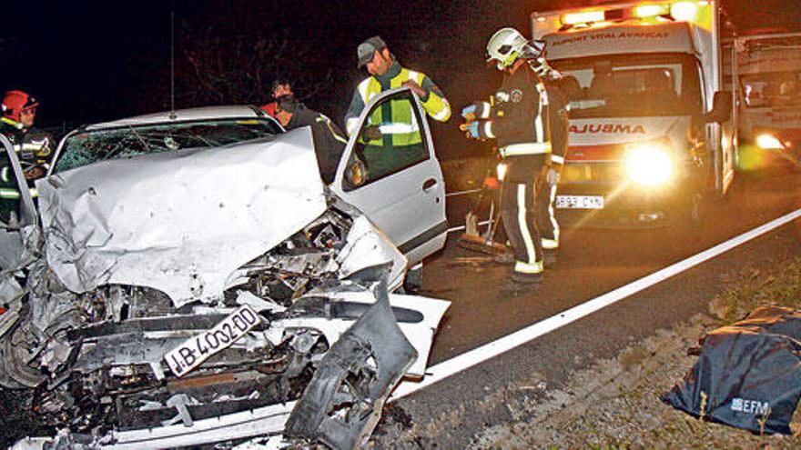 Varios bomberos, junto al cadáver de la víctima y los turismos implicados en el siniestro.