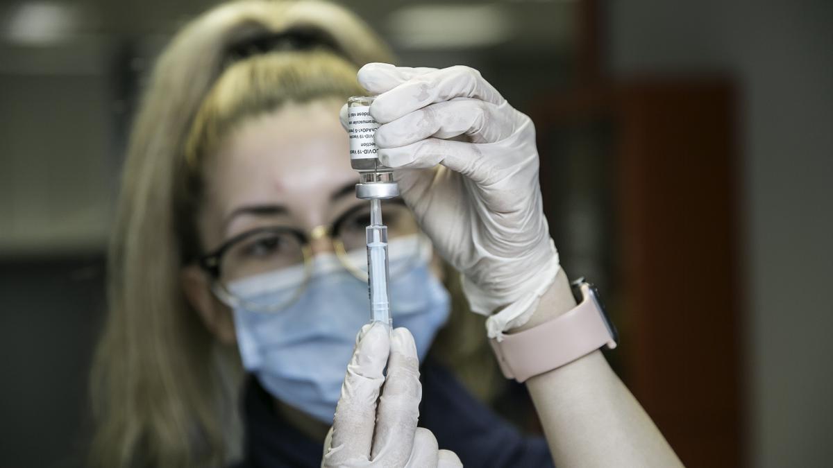 Una mujer sanitaria prepara una vacuna contra el COVID.