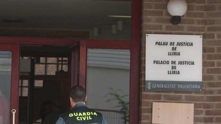 Un guardia civil entra en la sede de los juzgados de Llíria.