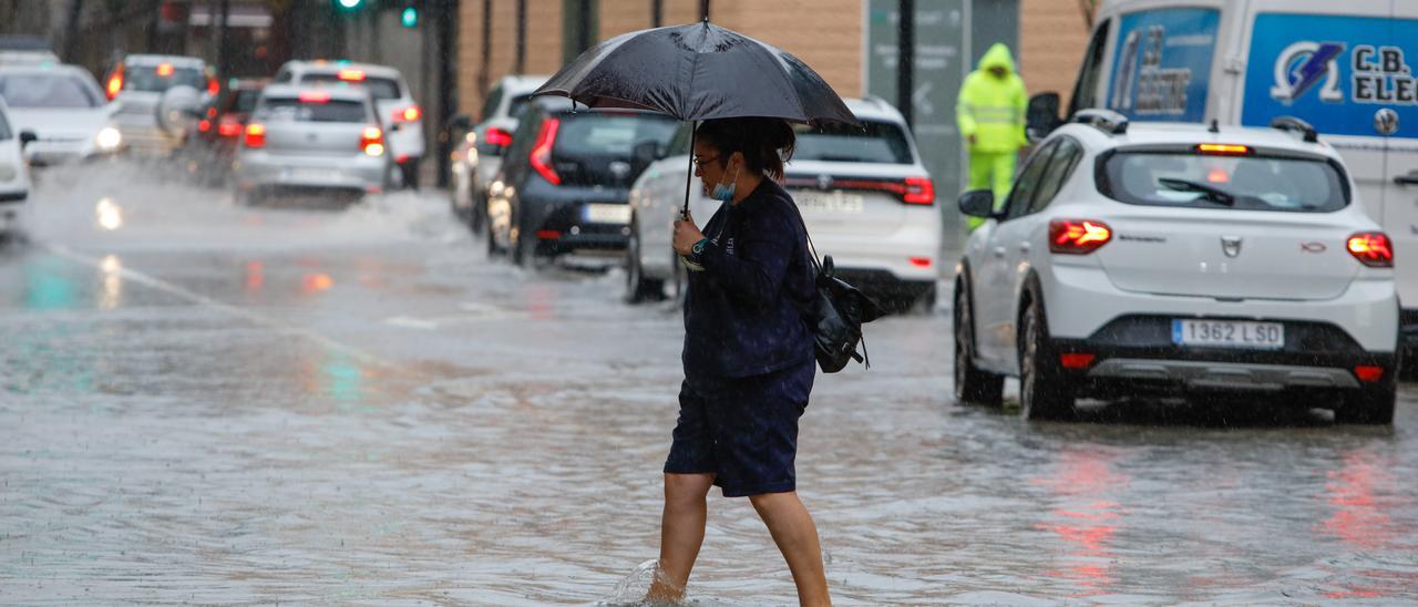 Una mujer cruza una calle inundada de Ibiza este octubre. Vicent Marí