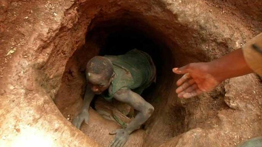 Un joven trabajador sale de una mina de coltán.