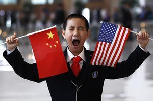 Un nen petit amb banderes dels EUA i de la Xina espera per saludar el Secretari d’Estat dels EUA, Hillary Clinton, al Museu Nacional de Pequín.