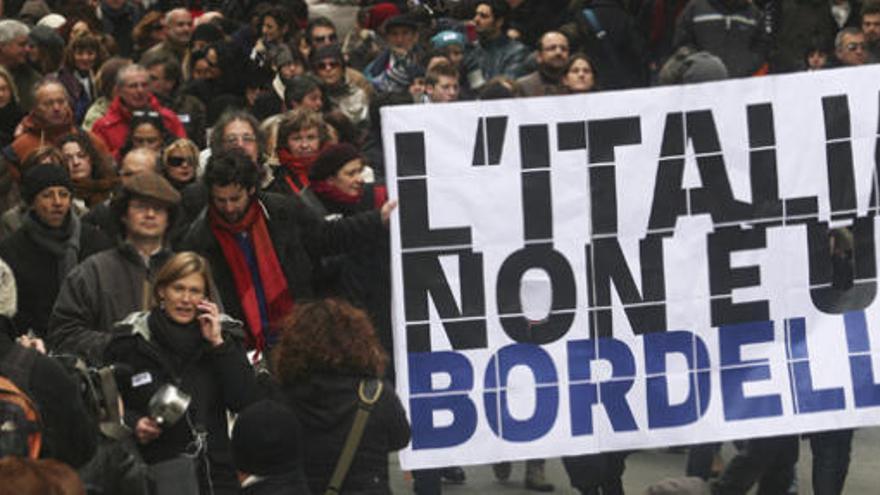 Manifestantes gritan consignas y muestran pancartas en las que se lee &quot;Italia no es un burdel&quot;.