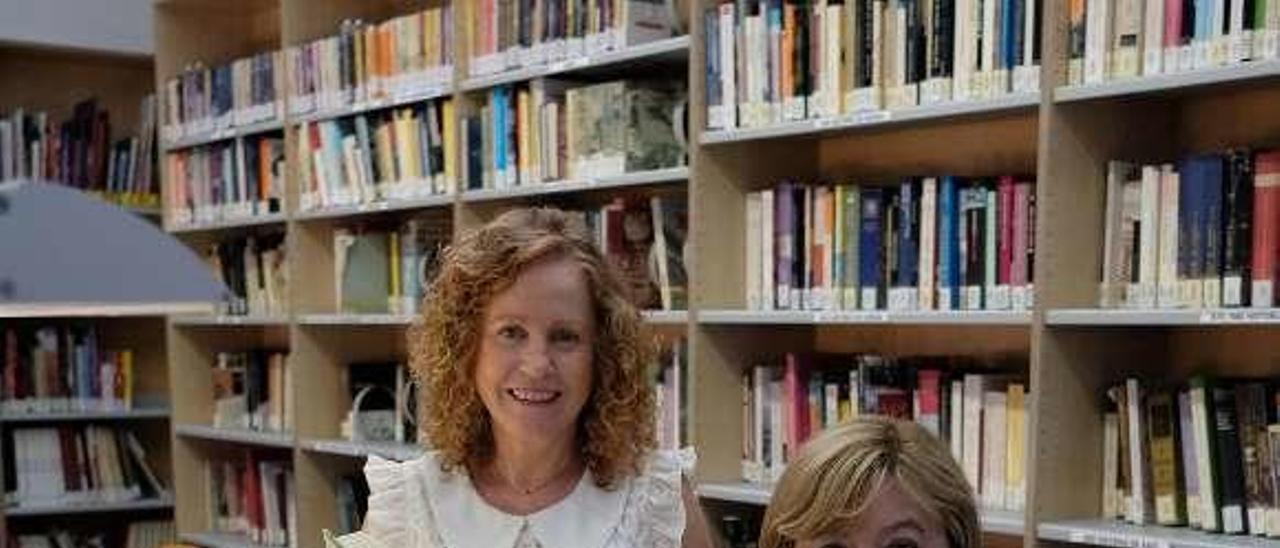 Las bibliotecarias Blanca Fernández y Elena Losa, en Mieres, con algunos de los libros recomendados para este verano.
