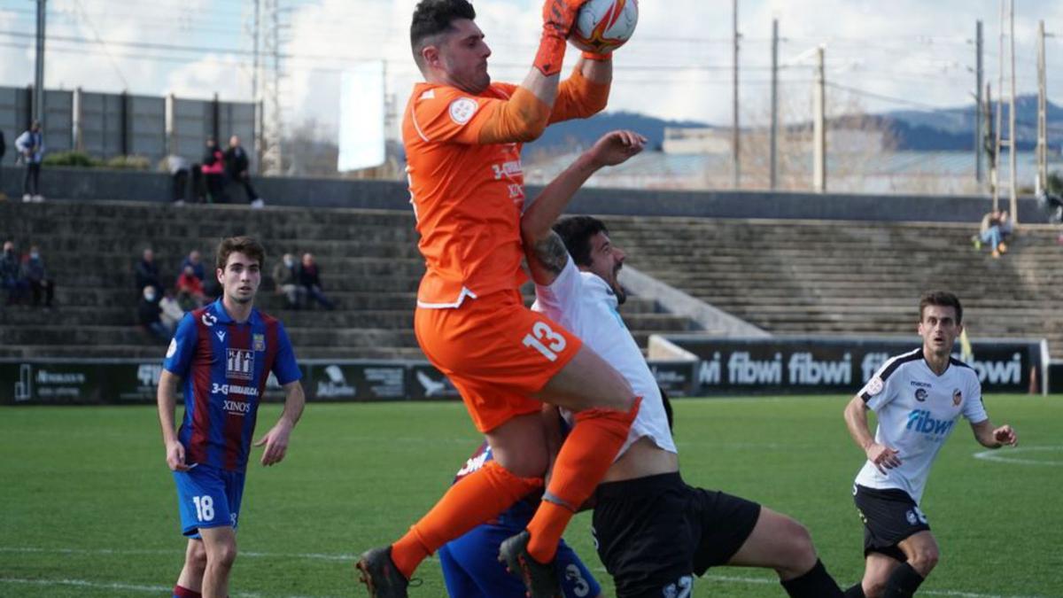 Juan Carlos bloca un balón ante César Ruiz del Constància.