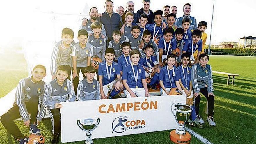 Los alevines del Oviedo, con el trofeo de ganadores de la Copa Integra, junto con Rergis, Manuel Paredes y César Martín.