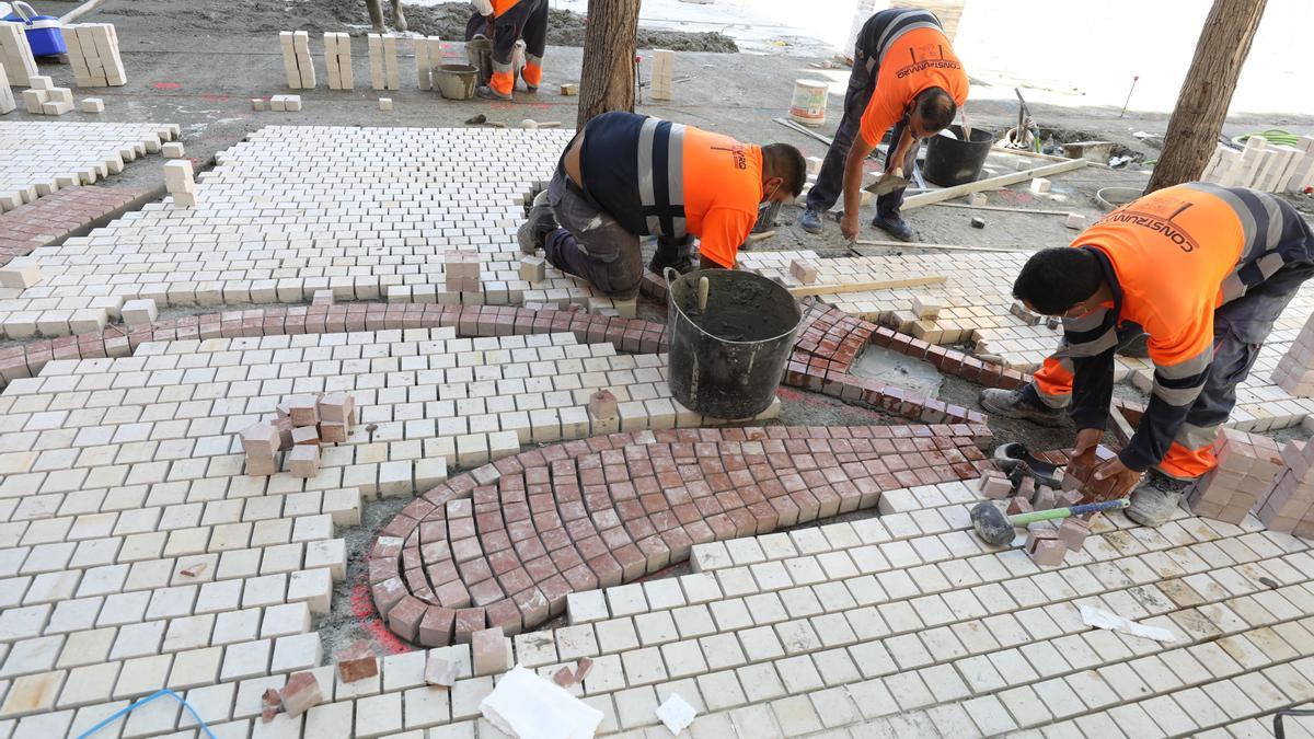 Los operarios colocaban la pasada semana los adoquines que forman el mosaico de 600.000 piezas inspirado en los orígenes íberos de Elche con el que se cubrirá la Plaça de Baix.