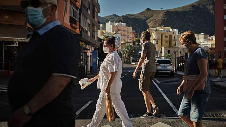 Personas con mascarilla cruzan una calle en Tenerife.