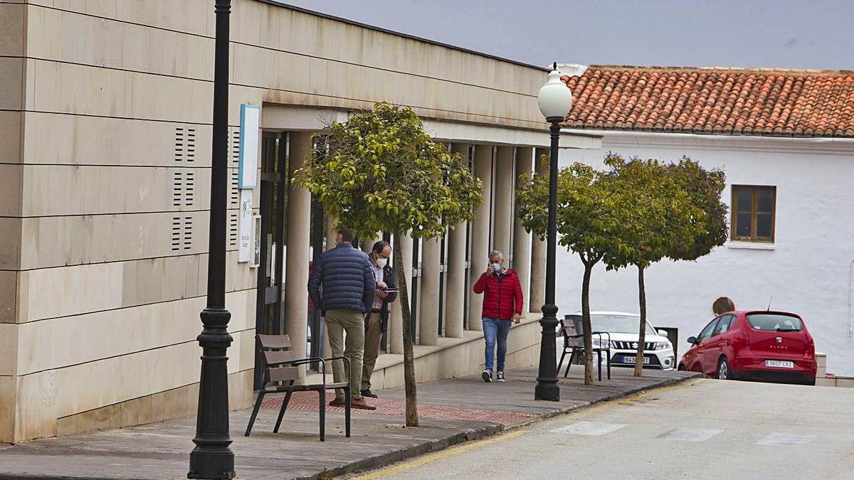 Vecinos de Bocairent esperan a que se les practique la PCR, ante el centro de salud ayer. A la derecha, enfermeras trabajando en el interior de las instalaciones | PERALES IBORRA