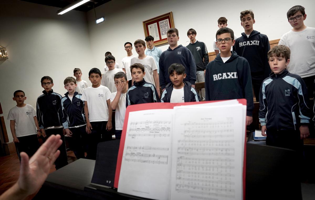 Los escolanos, de 9 a 18 años, durante el ensayo diario del coro en la Escolanía.