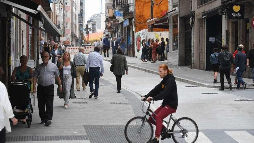 Peatones y un ciclista, ayer, en un tramo ya renovado de la calle de la Torre.