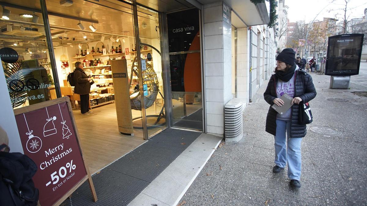 Una persona davant una botiga al centre de Girona, en una imatge d'arxiu.