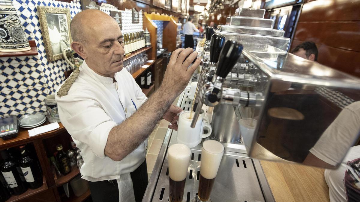 Un veterano camarero, tirando unas cervezas en un local de Barcelona.