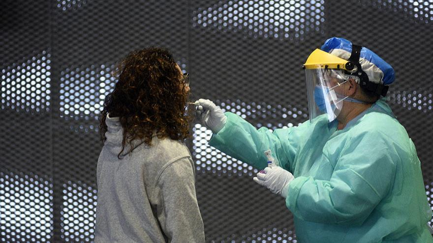 Una sanitaria toma muestras a una paciente en el punto de recogida del Reina Sofía.