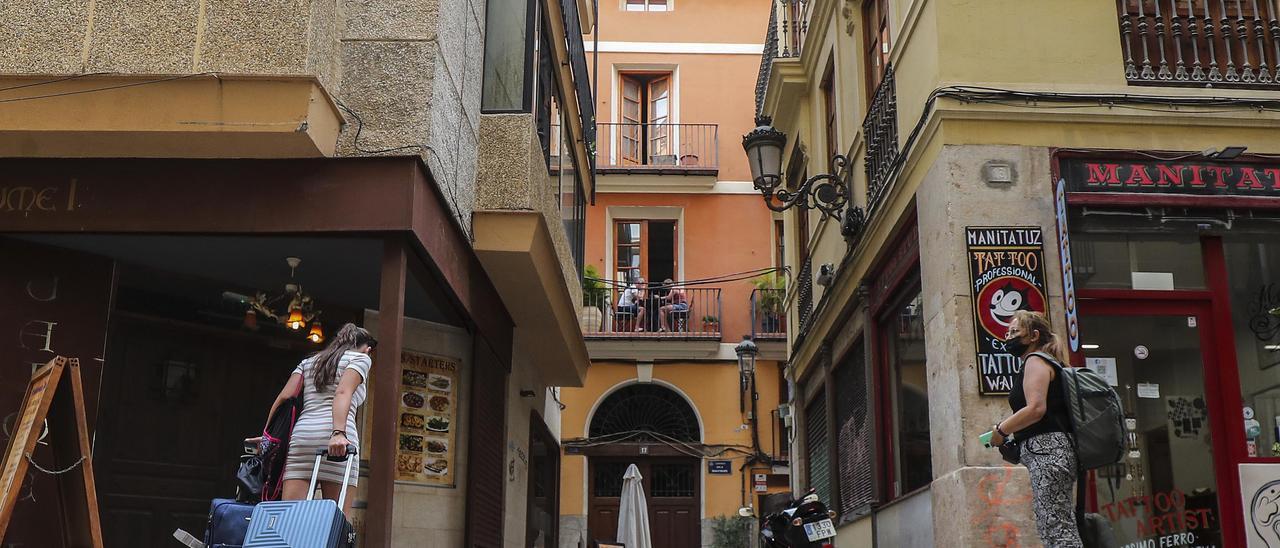 Dos turistas entran en un alojamiento turístico en València.