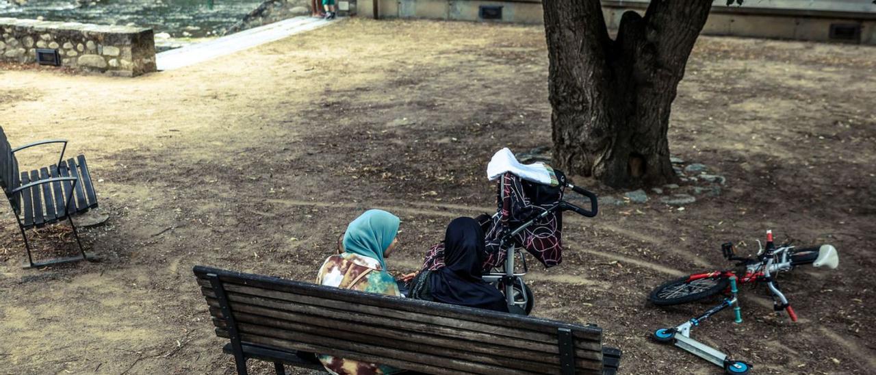 Dues dones d’origen migrant en una plaça de Ripoll.