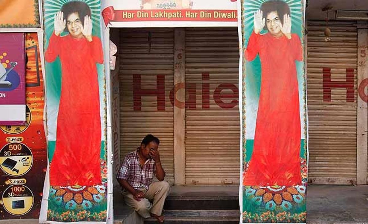 Un devot està assegut davant d’una botiga tancada a prop de l’’ashram’ (lloc de meditació) on jau el cos del líder espiritual hindú Sri Satya Baba. Va morir diumenge a la seva població natal, a Puttaparti, al sud de l’Índia.