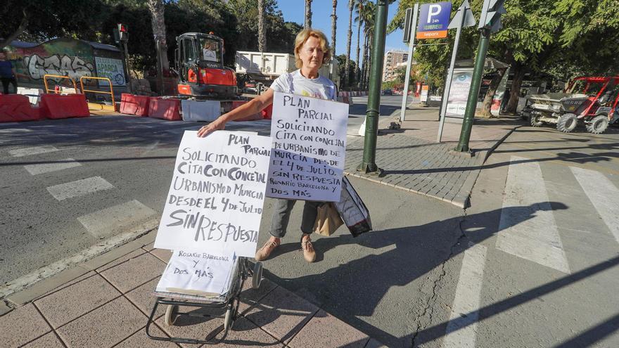 Una mujer pide reunirse con el concejal de Urbanismo paseándose por el centro de Murcia con pancartas