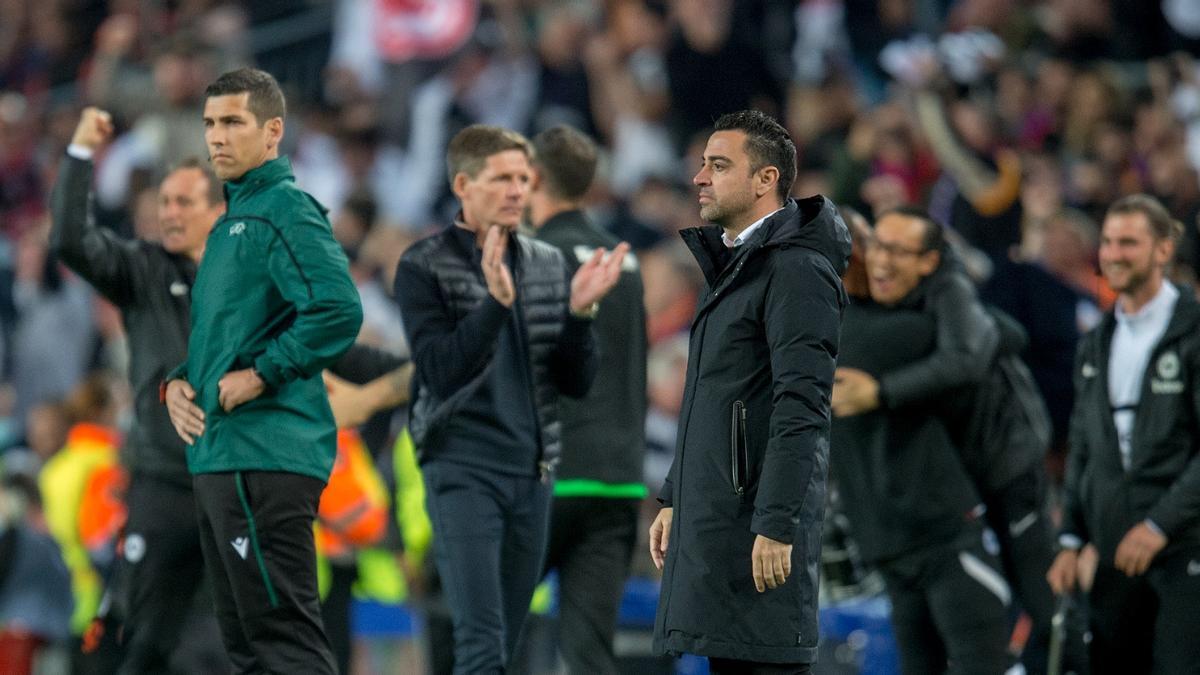 Los técnicos y suplentes del Eintracht celebran un gol ante Xavi en el Camp Nou.