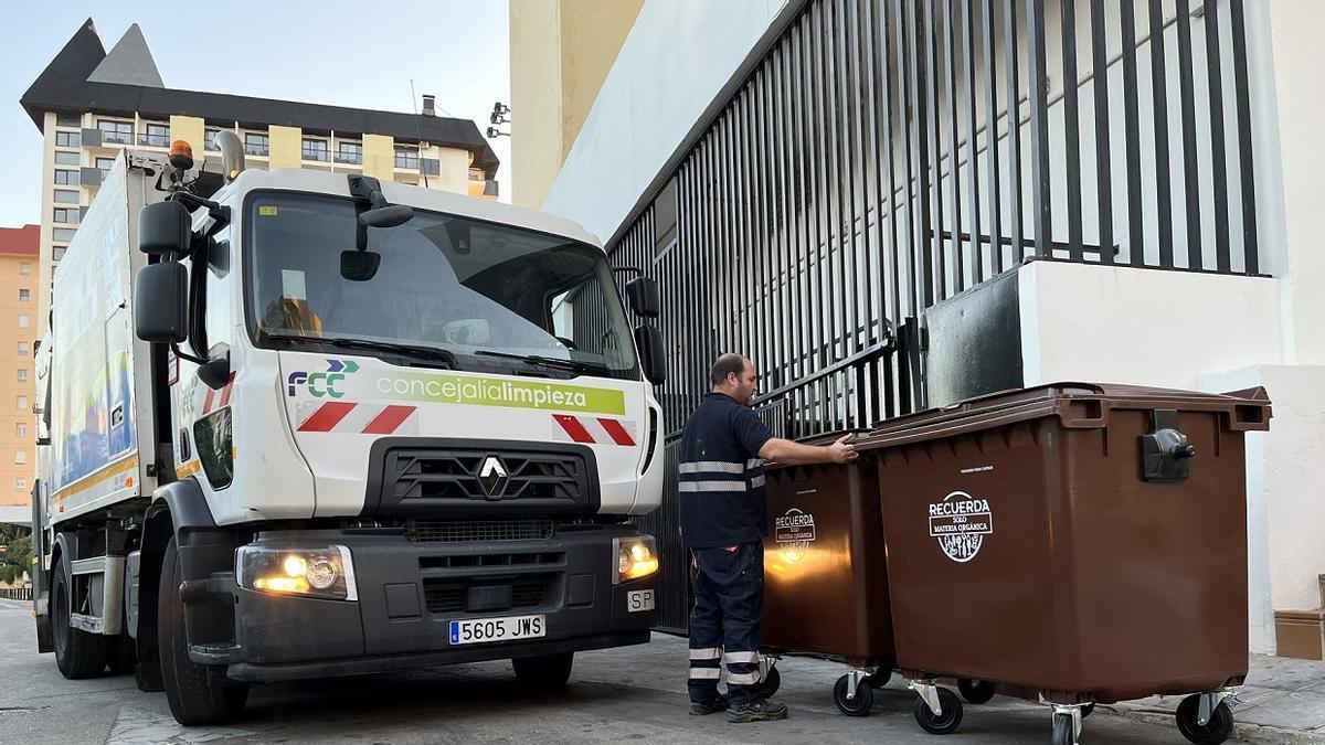 Un operario de Limpieza manipula los nuevos contenedores de color marrón en Fuengirola.