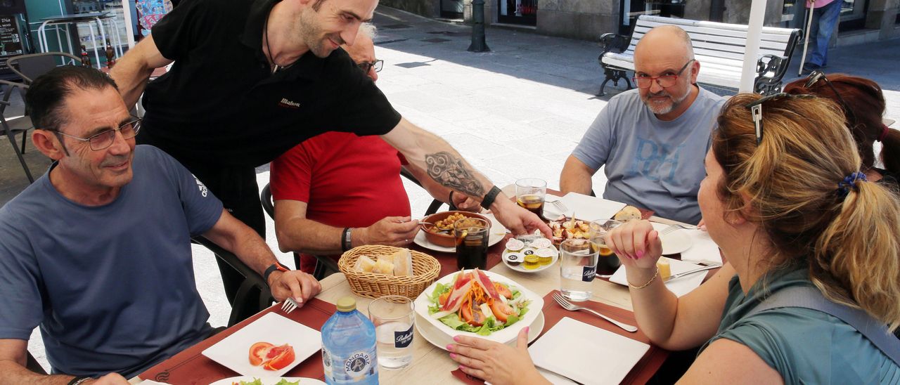 Un camarero sirve platos en la terraza de un restaurante ayer a la hora de comer.