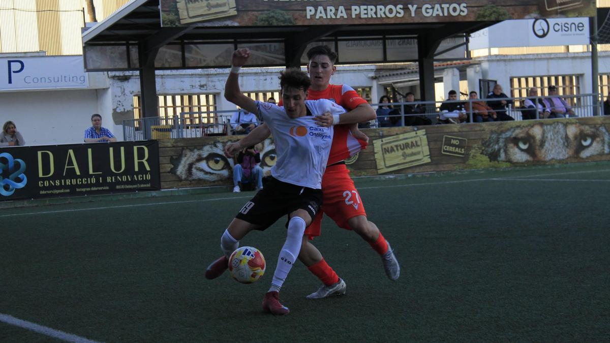 El Ontinyent 1931 controla el balón ante un rival en un partido.