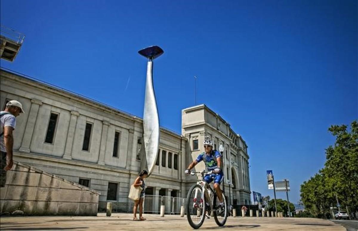 Un ciclista pedalea junto al Estadi Olímpic de Montjuïc.