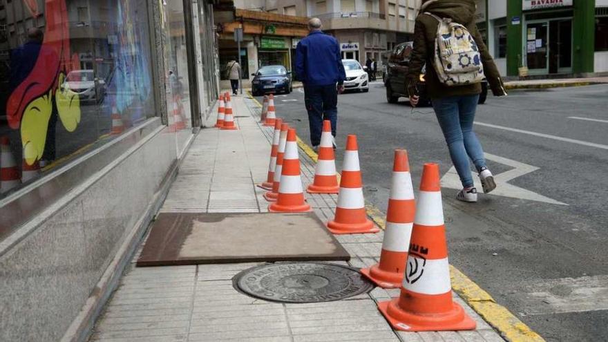 Los peatones tienen que bajarse de la acera para sortear los conos en Alejandro Cerecedo. // Noé Parga