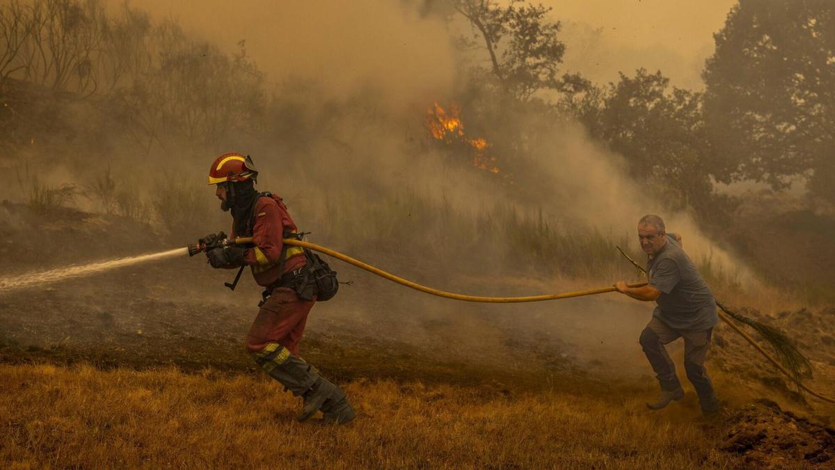 Un efectivo de la UME y un vecino durante la extinción de un incendio en Chandrexa de Queixa (Ourense) el pasado año.