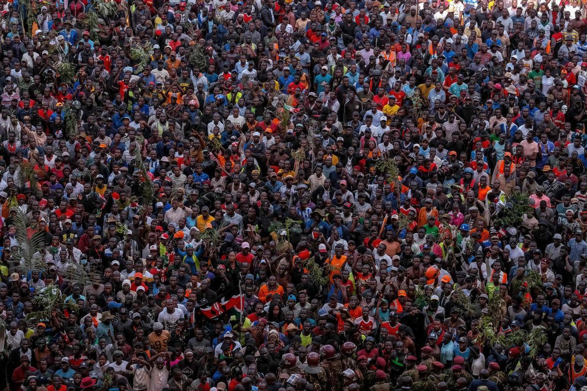 EDITORS NOTE: Graphic content / TOPSHOT - Supporters and mourners of Kenyan opposition leader Raila Odinga gather ahead of the public viewing of Odingas coffin at the Kasarani Stadium in Nairobi on October 16, 2025 following Odingas death at the age of 80 during a health visit to India. Tens of thousands of mourners fled in panic as police fired gunshots and teargas in a stadium where they had gathered to see the coffin of opposition leader Raila Odinga, whose body was repatriated from India on October 16, 2025. (Photo by KABIR DHANJI / AFP). Graphic content