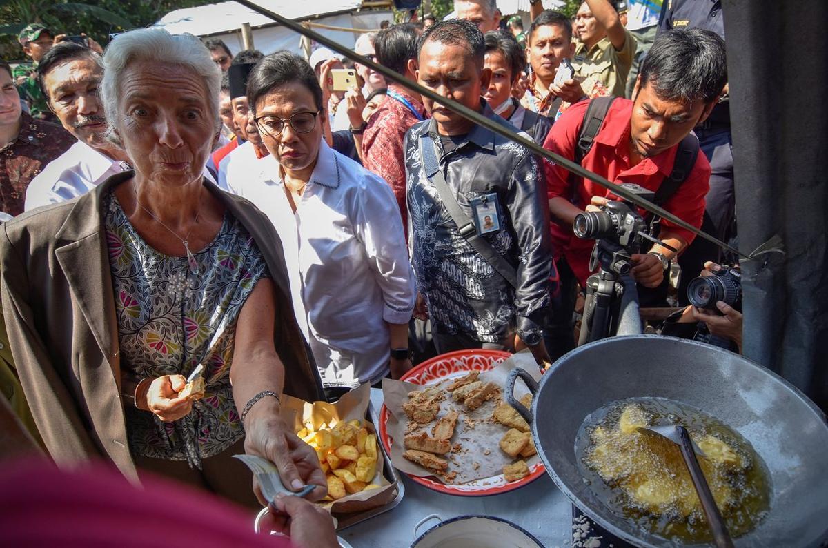 International Monetary Fund (IMF) Managing Director Christine Lagarde (L) buys traditional snacks from a vendor during her visit to an area affected by an earthquake at Gunungsari district, in West Lombok, Indonesia October 8, 2018. Antara Foto/Ahmad Subaidi via REUTERS  ATTENTION EDITORS - THIS IMAGE WAS PROVIDED BY A THIRD PARTY. INDONESIA OUT. MANDATORY CREDIT: ANTARA FOTO