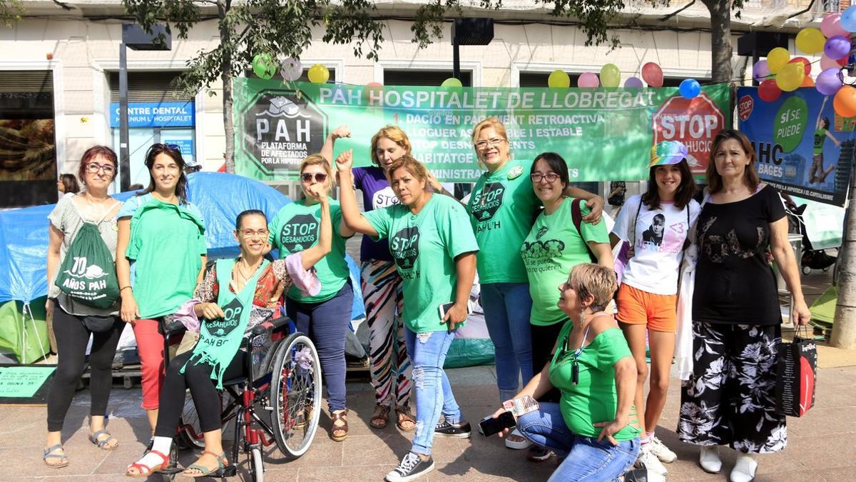 Íngrid (en el centro), acompañada por miembros de la PAH, frente a la tienda de campaña plantada delante del ayuntamiento de Hospitalet de Llobregat, donde hace 60 días que vive.