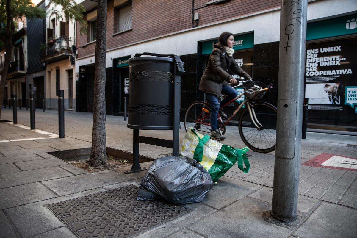 Bolsas de basura junto a una papelera en Sant Andreu, en Barcelona.