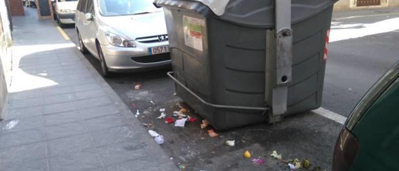 Un contenedor de la Mancebería rodeado de bolsas por la noche y de restos de basura al día siguiente.