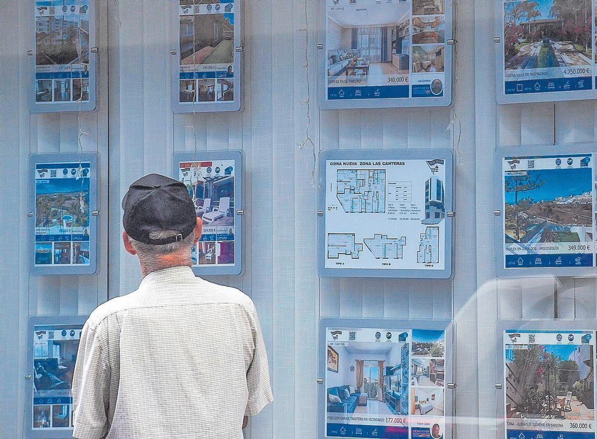Un hombre mira los anuncios de una inmobiliaria