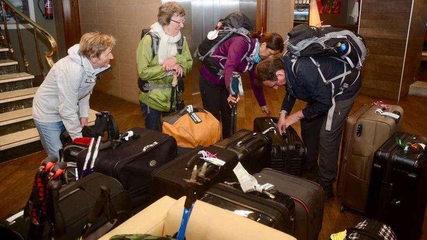 Turistas con sus equipajes en el recibidor de un hotel del centro de Pontevedra. // Rafa Vázquez