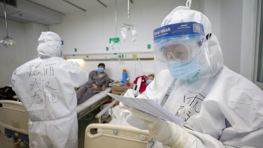 Dos médicos protegidos con trajes.