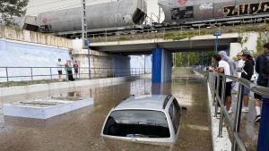 Un coche por debajo de la línea de agua, en uno de los puentes del barri del Serrallo, en Tarragona, este lunes por la tarde.
