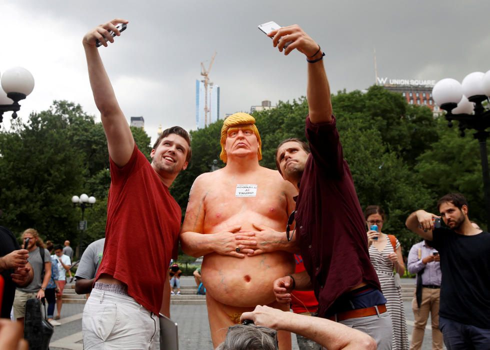 Viandantes se hacen selfies con una estatua de Donald Trump desnudo.