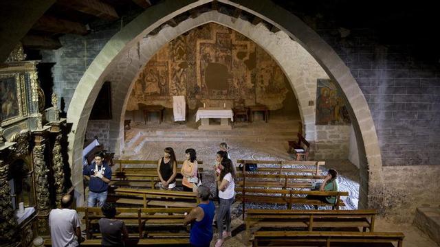 Visitantes atienden a las explicaciones de un guía en un templo de la Hoya. | COMARCA HOYA DE HUESCA