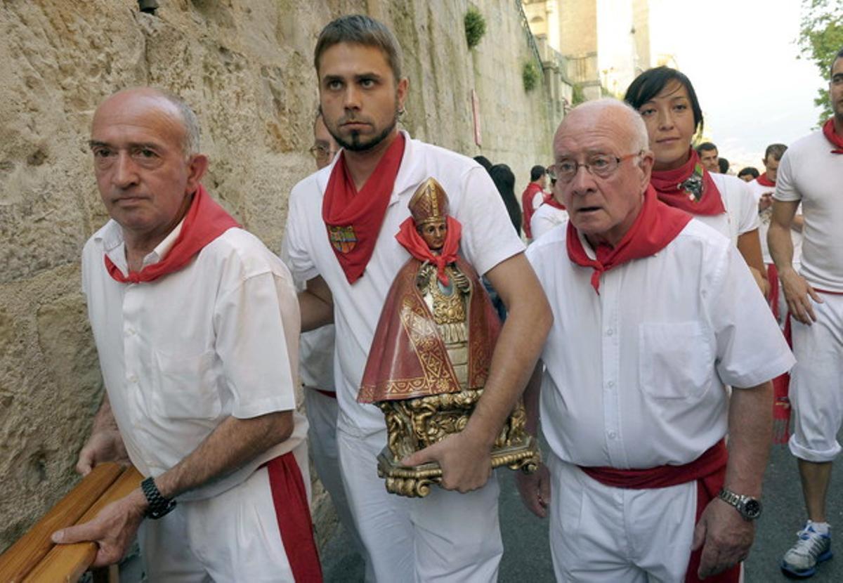 Un mosso pamplonès retira la imatge de sant Fermí de la fornícula de la costa de Santo Domingo fins l’any que ve.