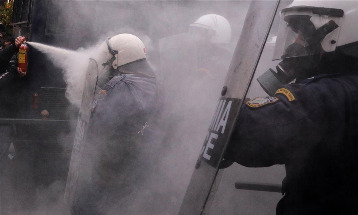 Un manifestante usa un extintor de incendios contra la policía antidisturbios durante los enfrentamientos fuera del edificio del parlamento. los maestros de escuelas griegas se manifiestan contra los planes del gobierno para cambiar los procedimientos de contratación en el sector público en Atenas, Grecia.