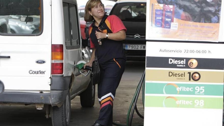 Una empleada poniendo carburante a un coche.