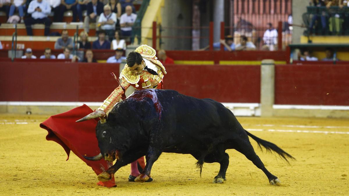 Paco Ureña intenta conducir lo más lejos posible la indómita y descompuesta arrancada del toro, que se estira, contorsionado.