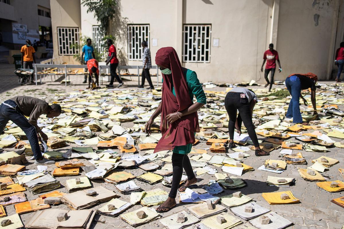 9 de junio de 2023, Dakar, Senegal.- Estudiantes tratan de rescatar algunos documentos quemados durante las protestas contra el presidente en la universidad Cheikh Anta Diop de Dakar.