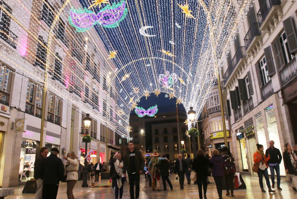 La principal calle del centro de Málaga ya luce los motivos carnavalescos, máscaras y antifaces, con motivo de la Fiesta del Invierno Cálido de la ciudad