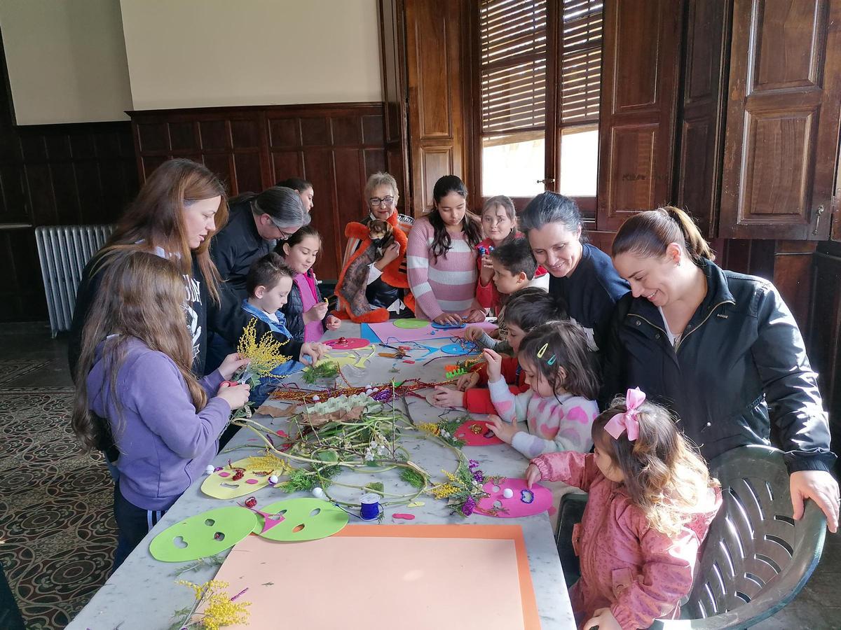 Padres ayudan a los niños a decorar las mascaradas creadas en el taller.
